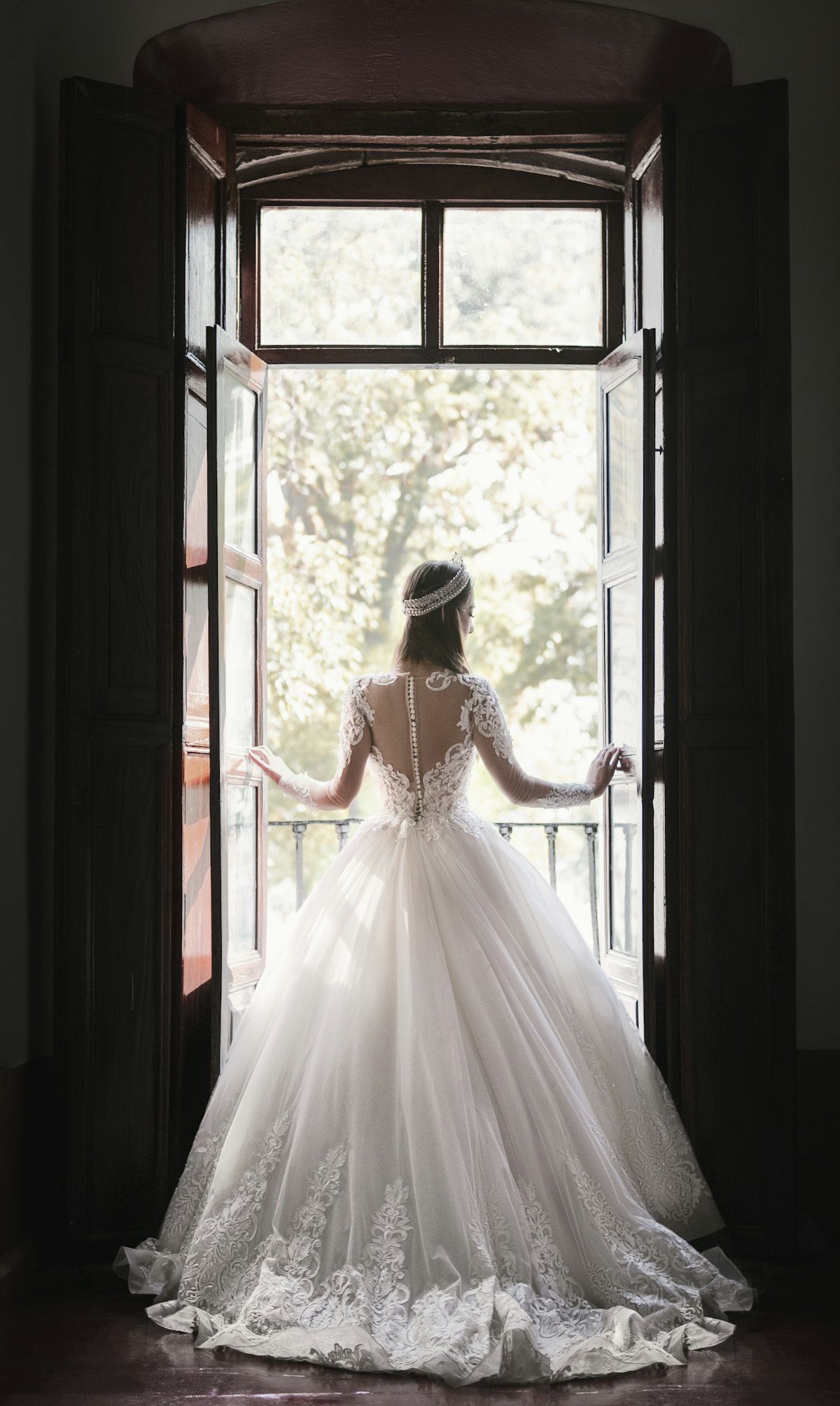 Sposa in abito su misura davanti a una finestra